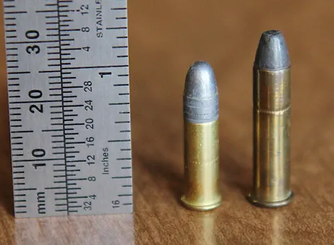 .22 LR cartridge beside .22 WRF with a ruler